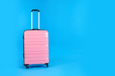 Photo of Travel pink suitcase on light blue background, space for text. Summer vacation
