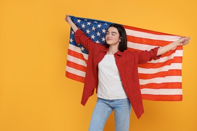 Photo of 4th of July - Independence Day of USA. Happy girl with American flag on yellow background, space for text