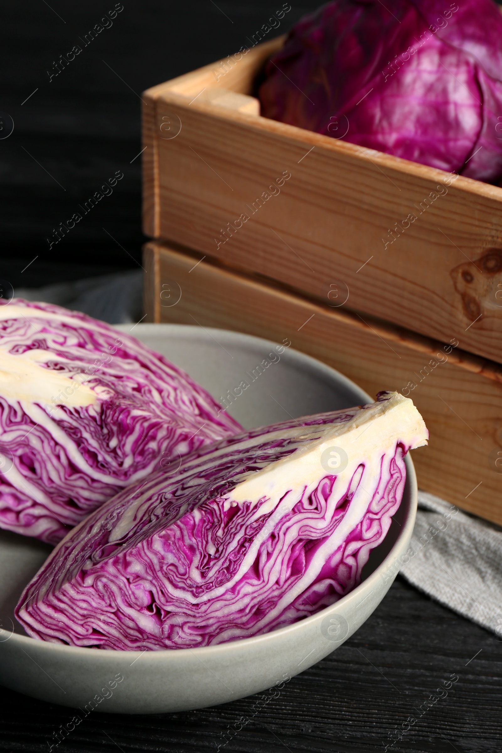 Photo of Fresh red cabbages on black wooden table