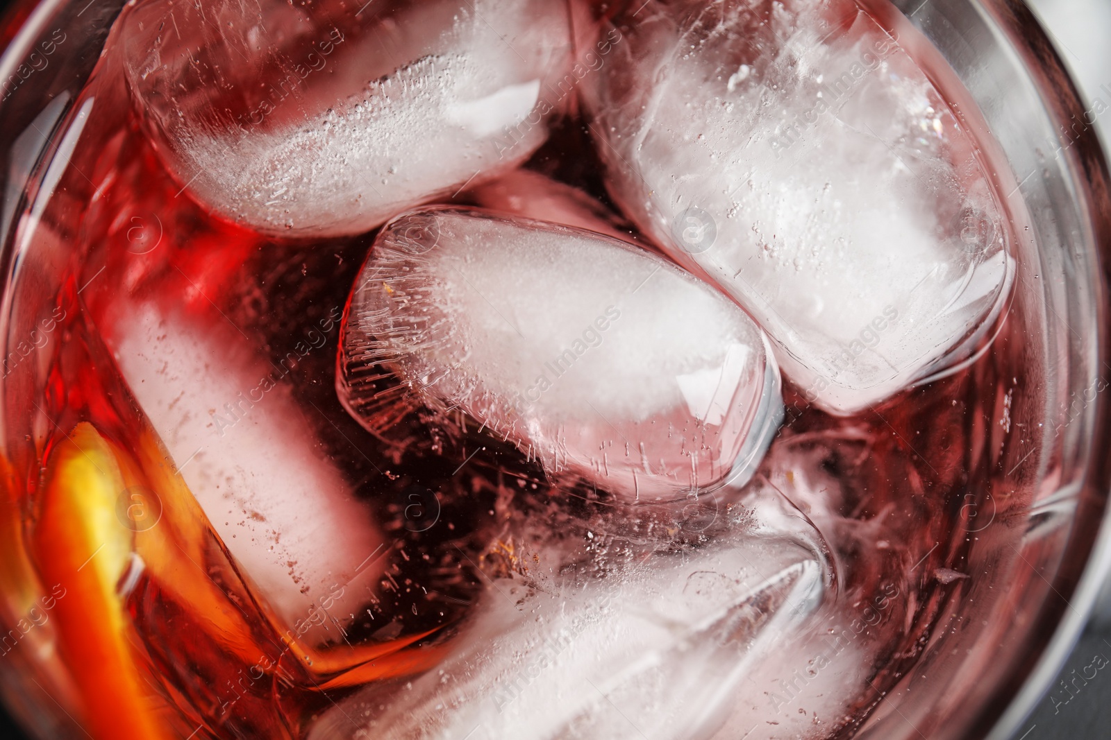 Photo of Refreshing cocktail with ice cubes in glass, top view