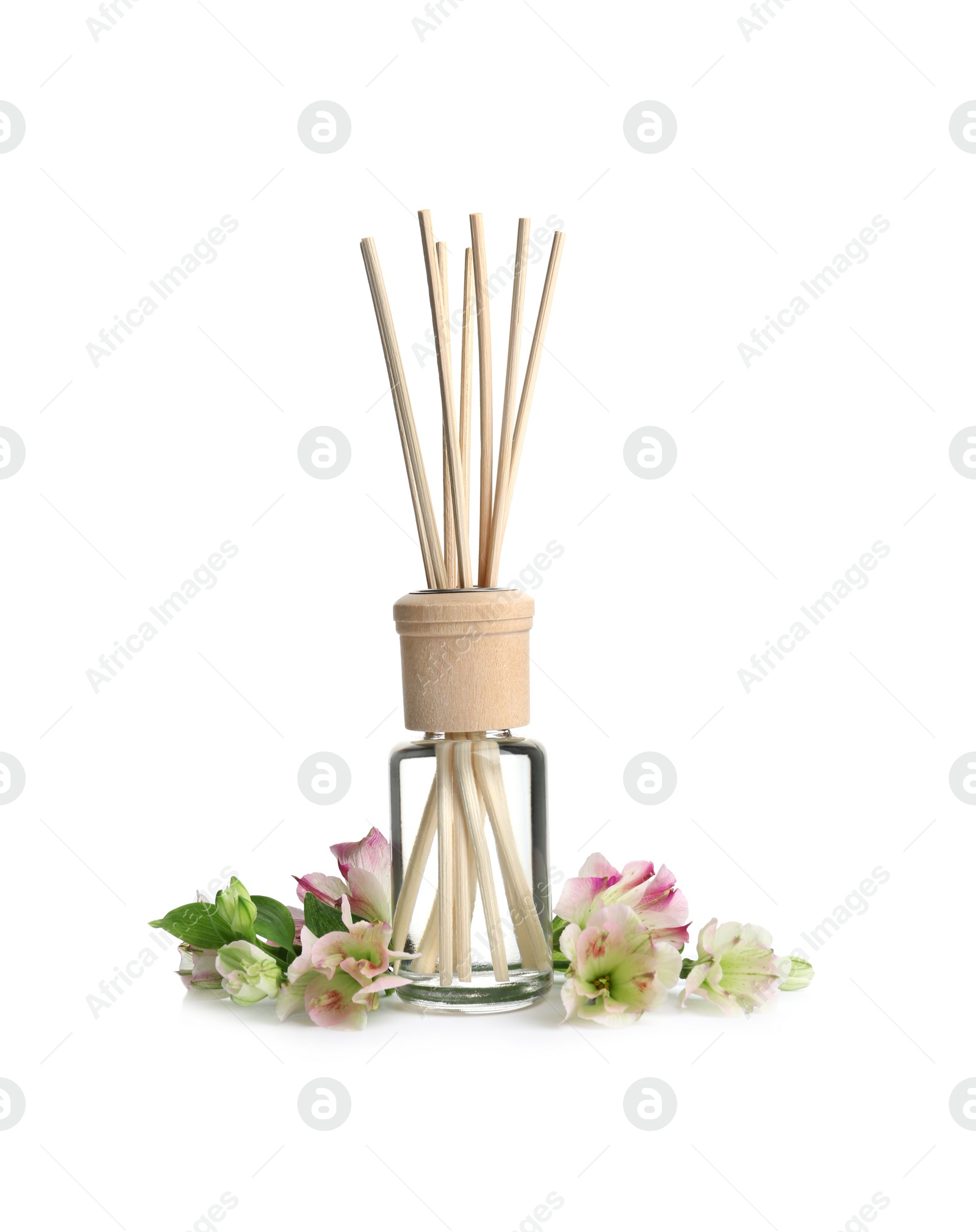 Photo of New reed air freshener and flowers on white background