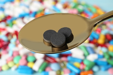 Spoon with weight loss pills over table, closeup