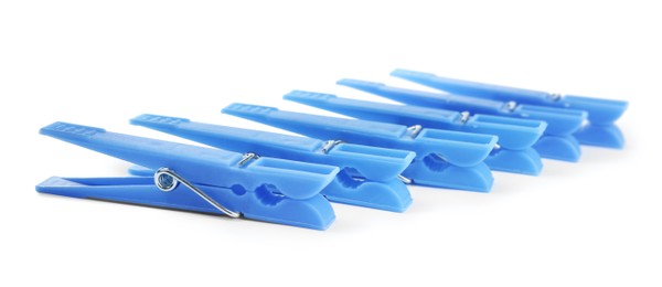 Photo of Light blue plastic clothespins on white background