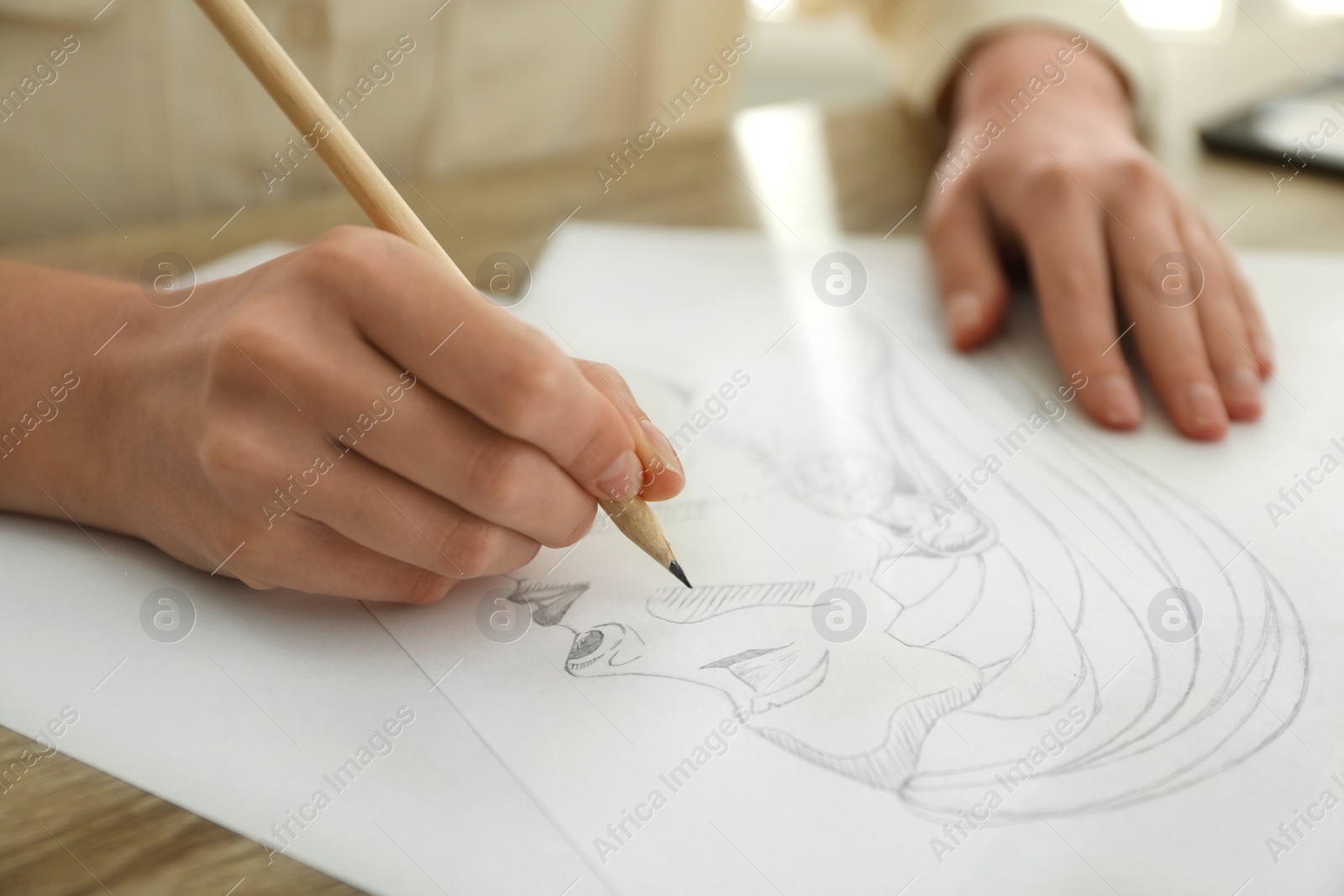 Photo of Woman drawing girl's portrait with pencil on sheet of paper at table, closeup