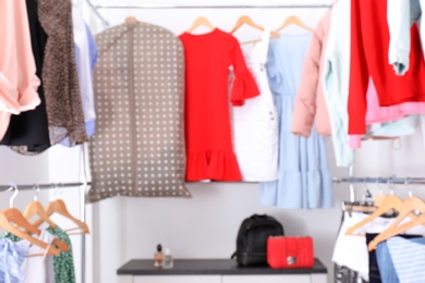 Photo of Blurred view of dressing room with different clothes and accessories