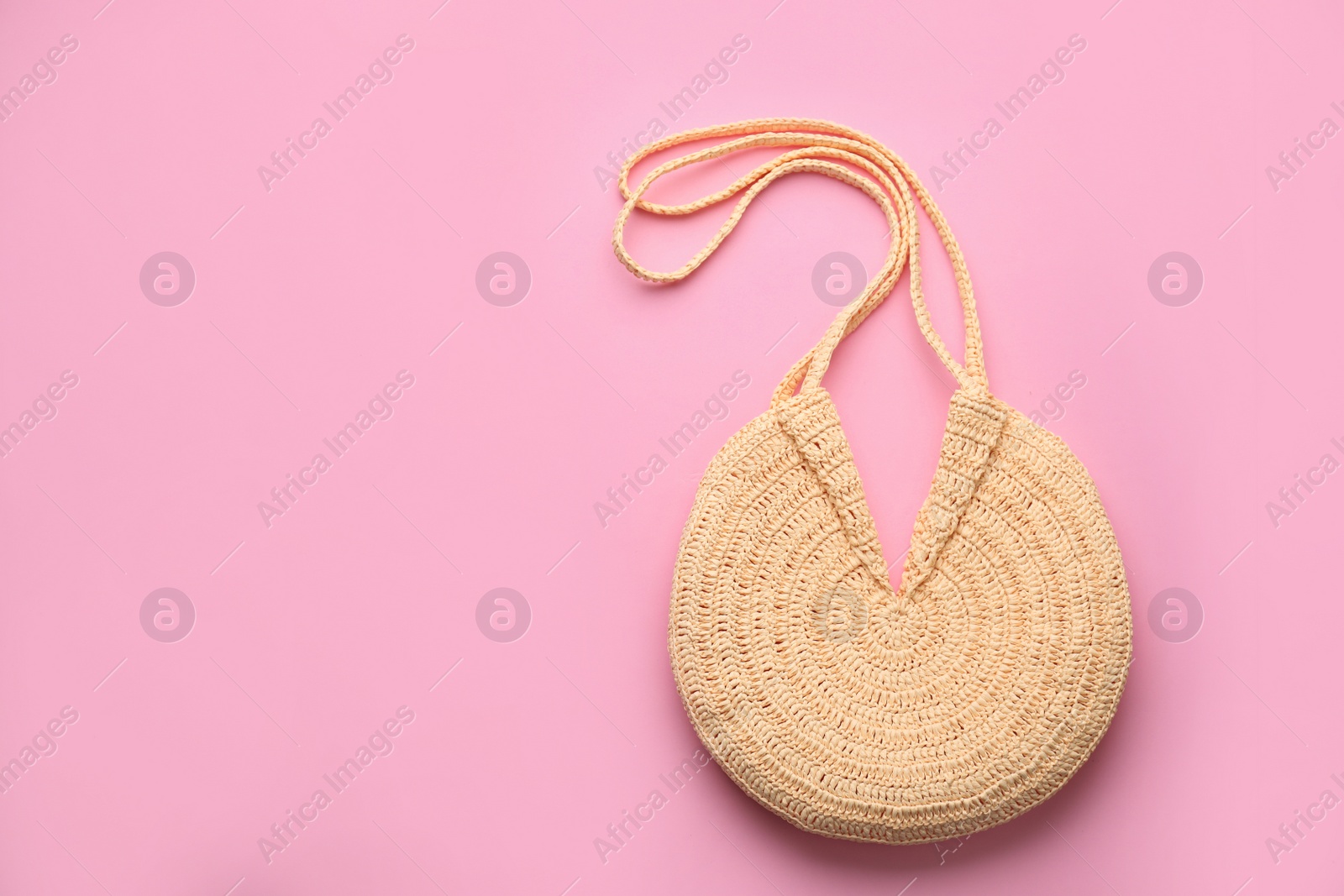 Photo of Elegant woman's straw bag on pink background, top view. Space for text