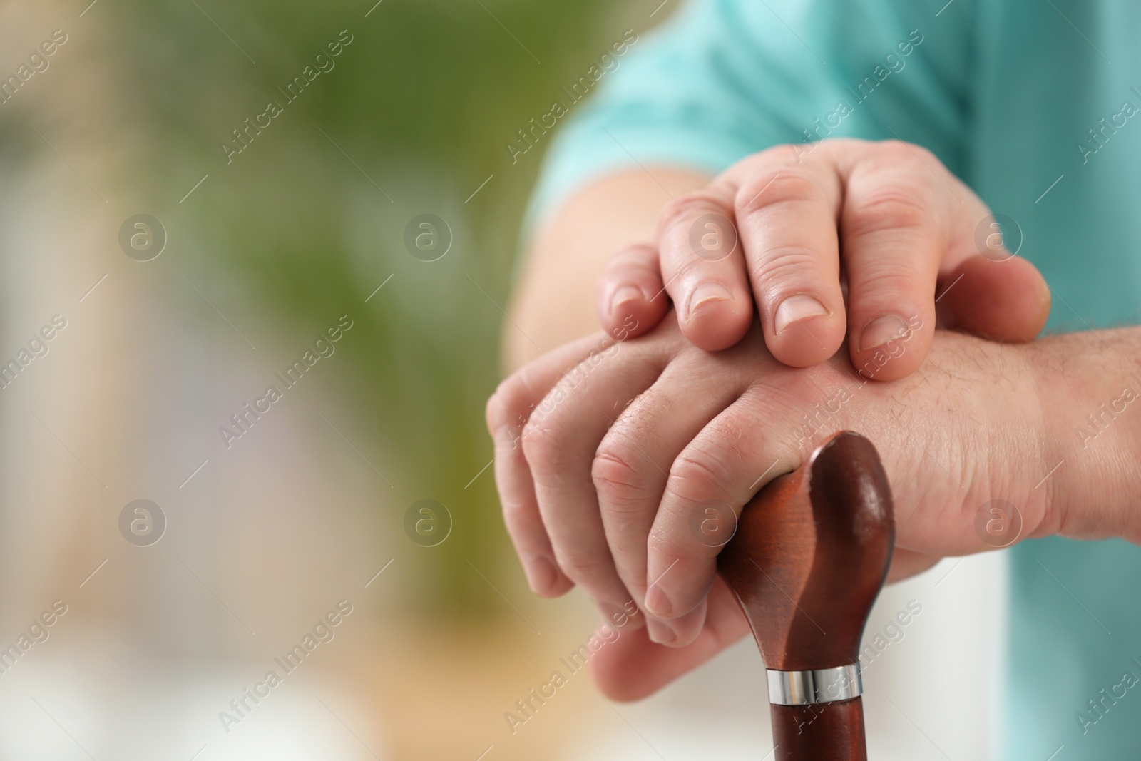 Photo of Closeup view of elderly man with cane in nursing home, space for text. Assisting senior generation