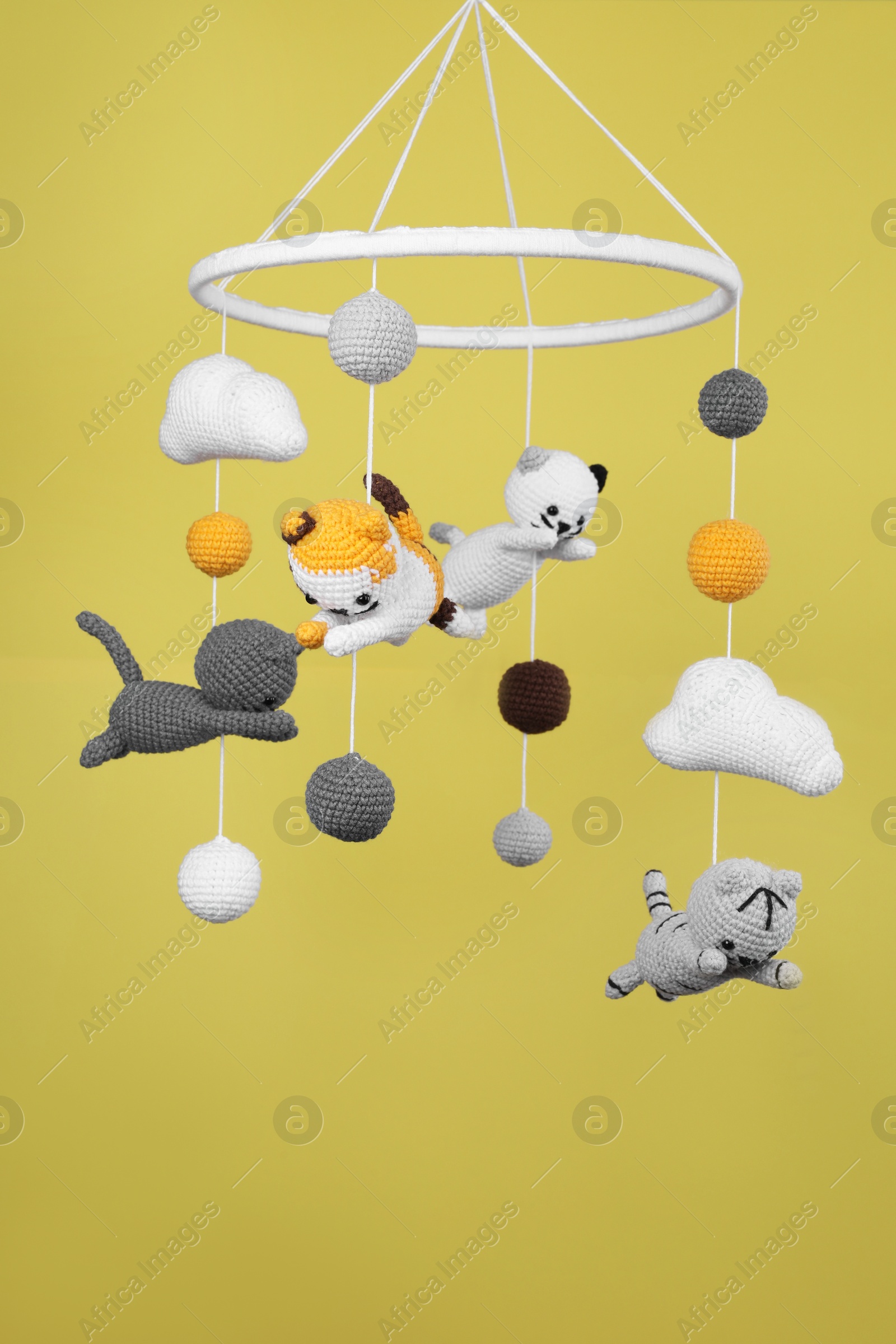 Photo of Cute baby crib mobile on yellow background
