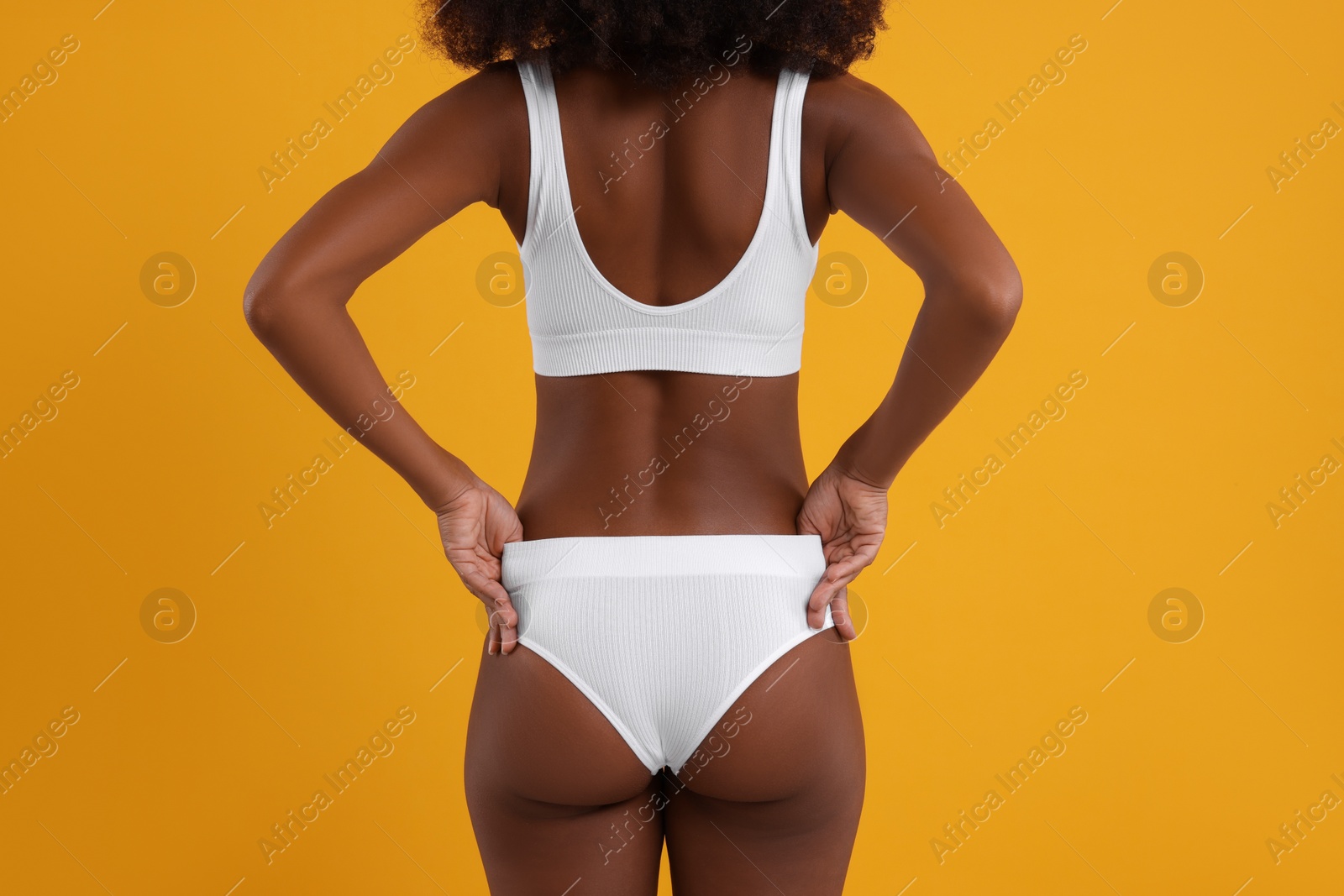 Photo of Woman in stylish bikini on yellow background, closeup