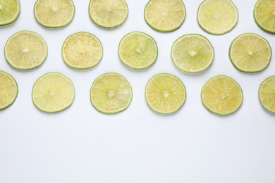 Photo of Fresh juicy lime slices on white background, top view