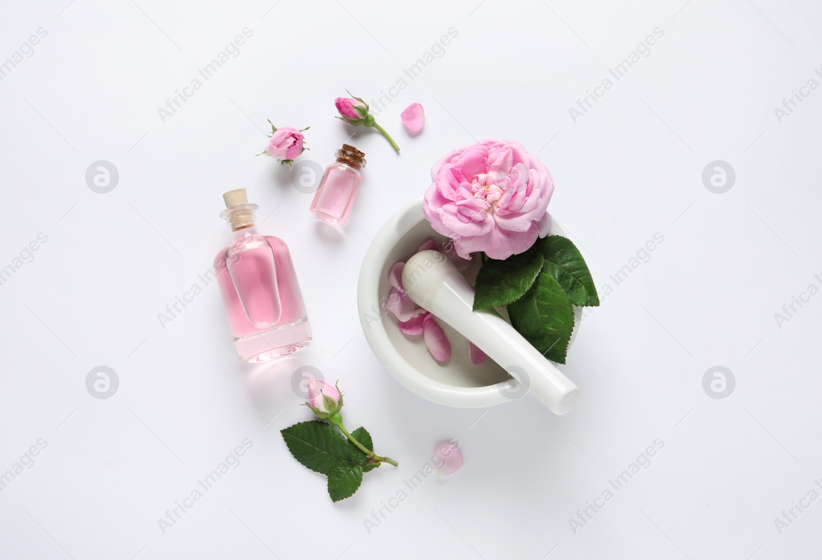 Photo of Composition with rose essential oil and flowers on white background, top view