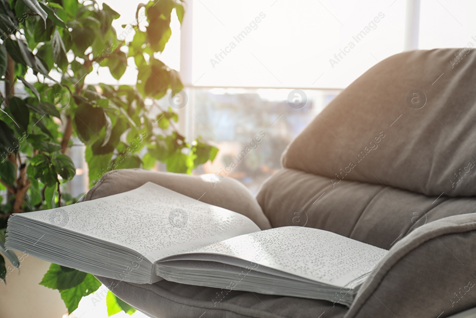 Photo of Book with Braille text on armchair. Education for blind people