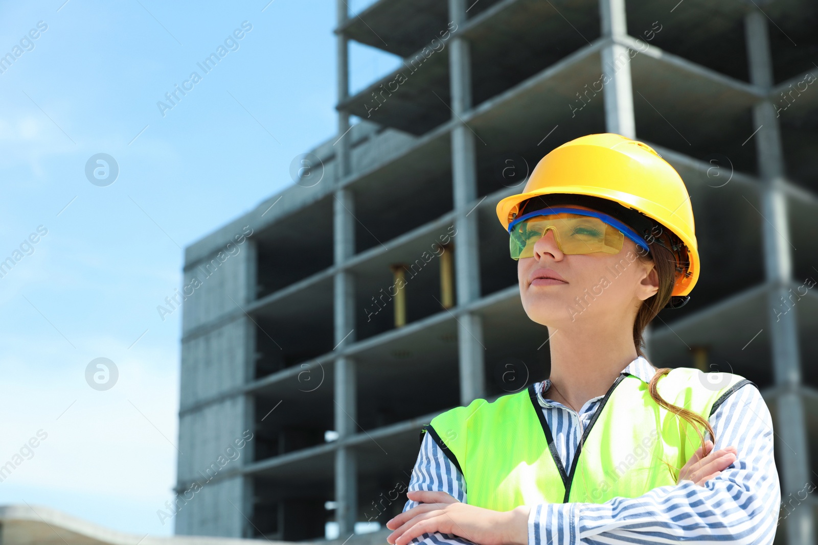 Photo of Professional engineer in safety equipment at construction site, space for text