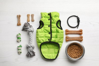 Photo of Flat lay composition with clothes, food and accessories for dog on white wooden table