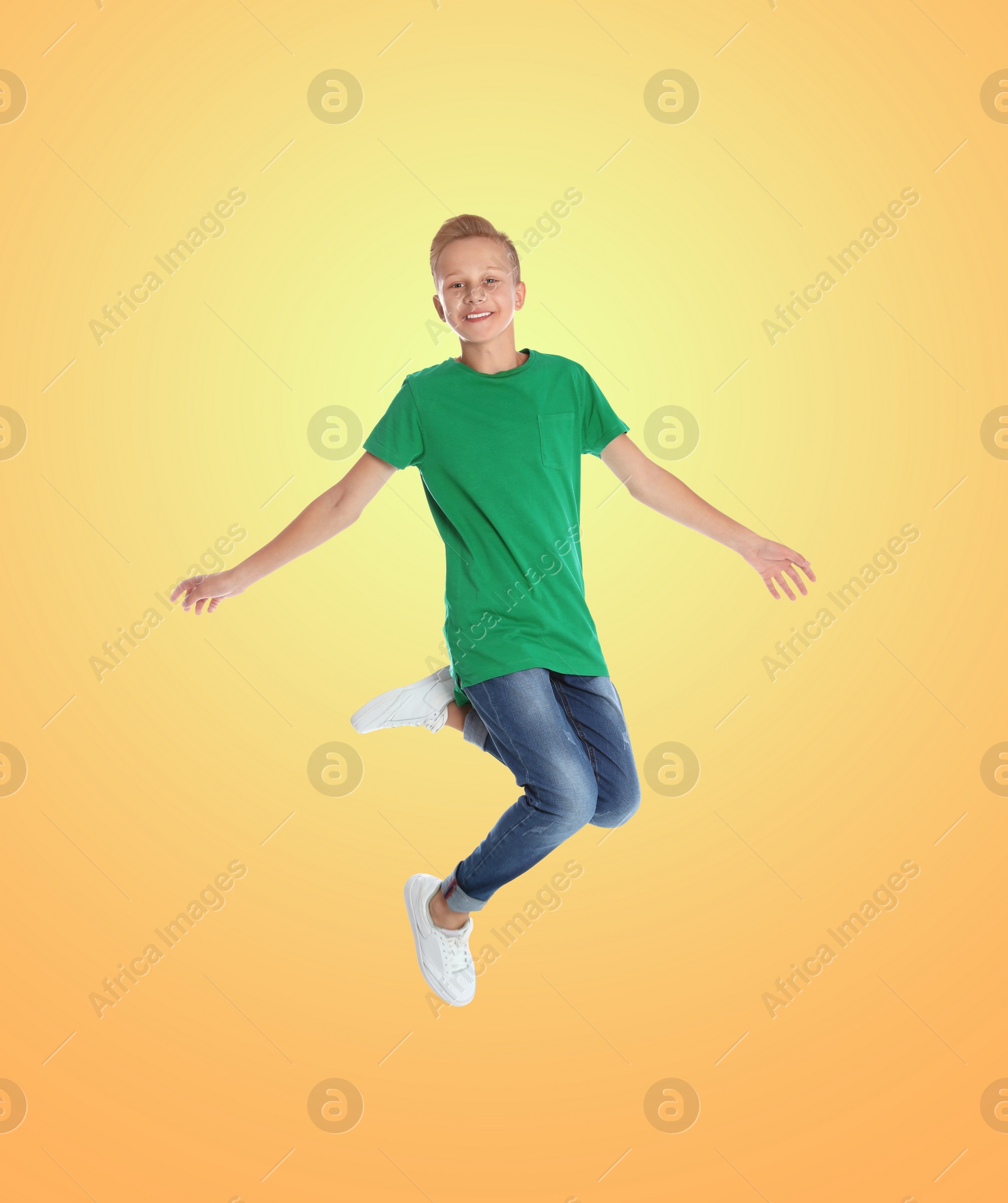 Image of Happy boy jumping on color gradient background