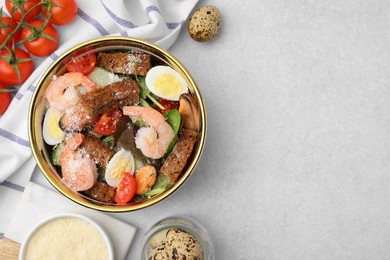 Delicious salad with croutons, tomatoes and shrimp served on white table, flat lay. Space for text