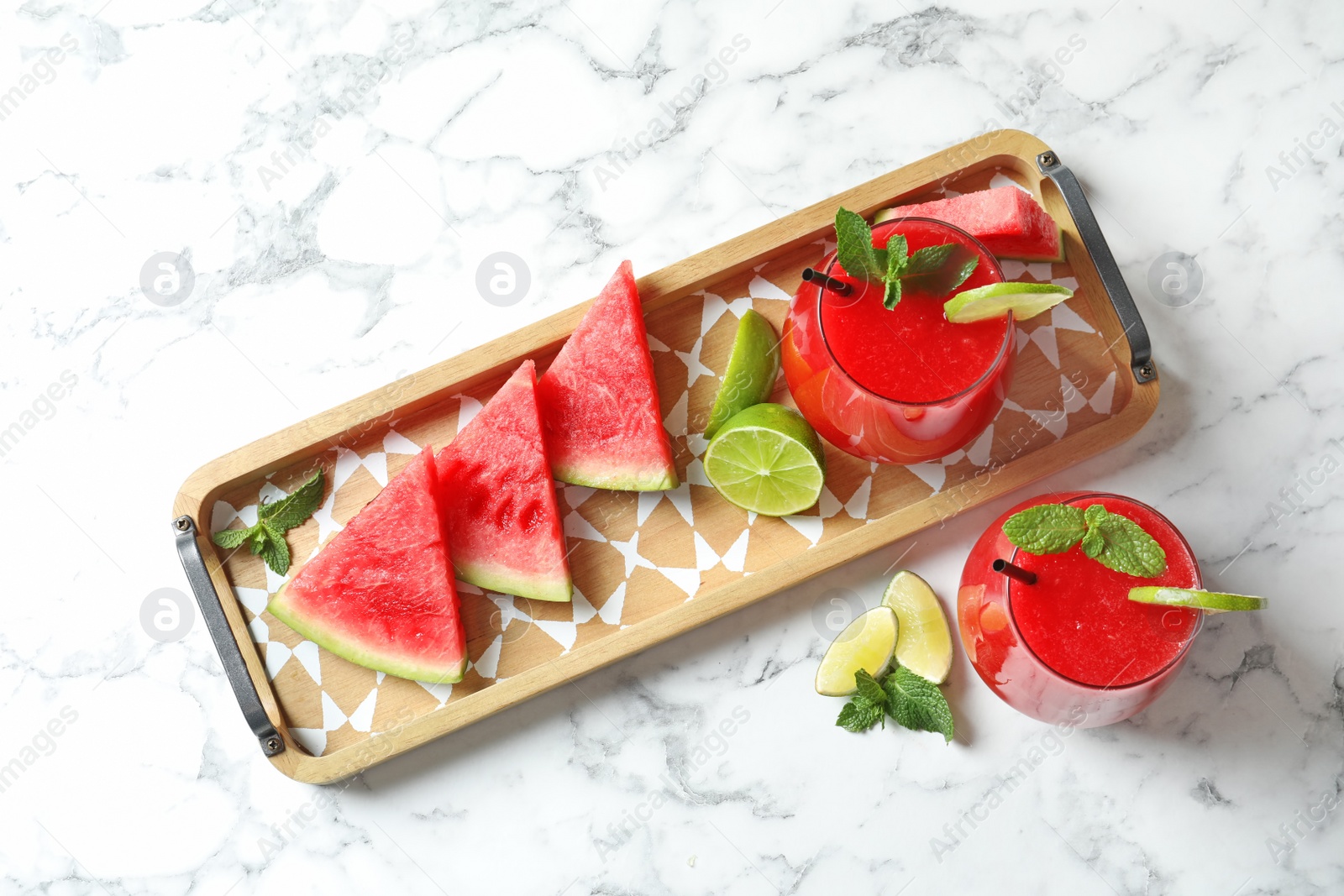 Photo of Summer watermelon drink in glasses and sliced fruits on table, top view