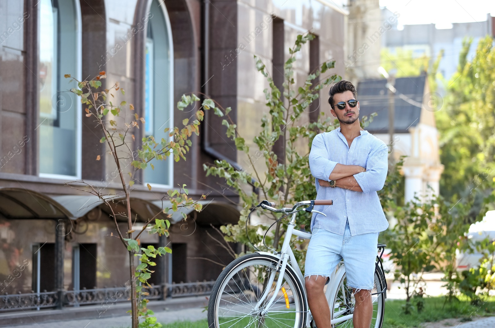 Photo of Handsome young hipster man with bicycle outdoors