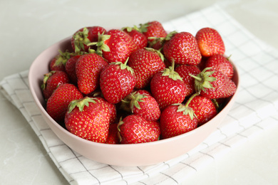 Photo of Delicious ripe strawberries in bowl on light grey marble table, closeup