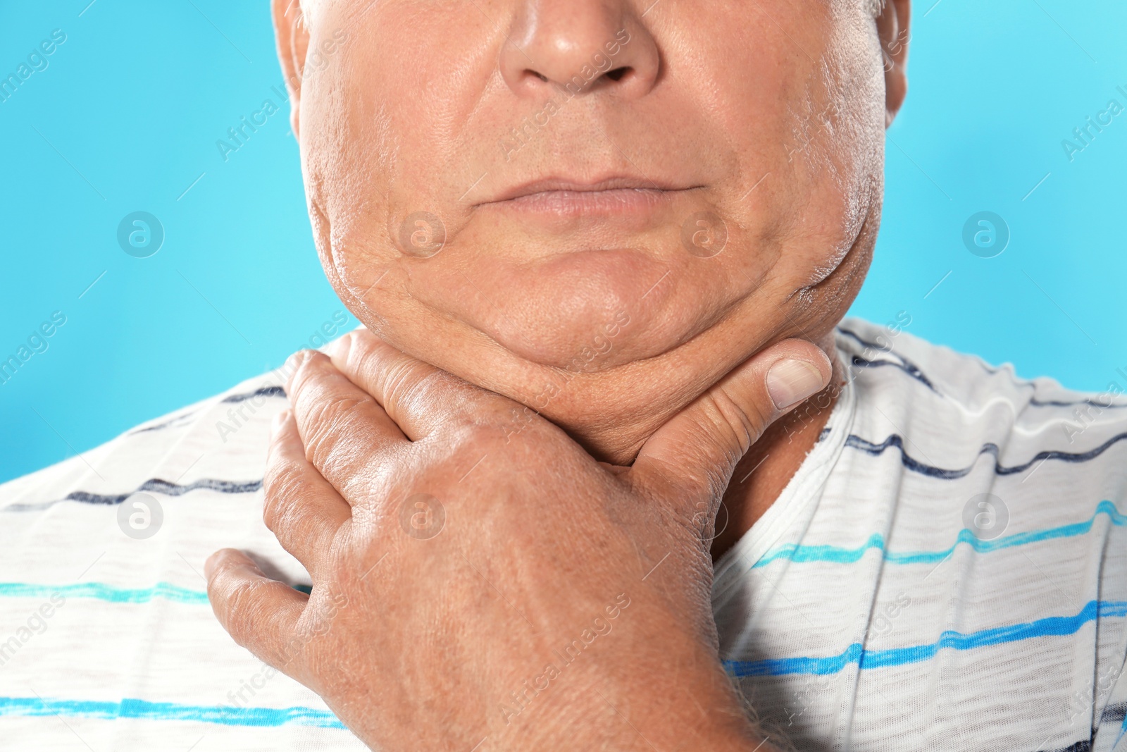 Photo of Mature man with double chin on blue background, closeup