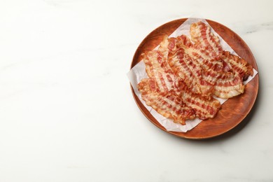 Photo of Delicious fried bacon slices on white marble table, top view. Space for text