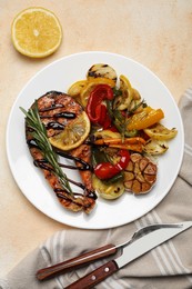 Tasty salmon steak with sauce, lemon and vegetables on light table, flat lay