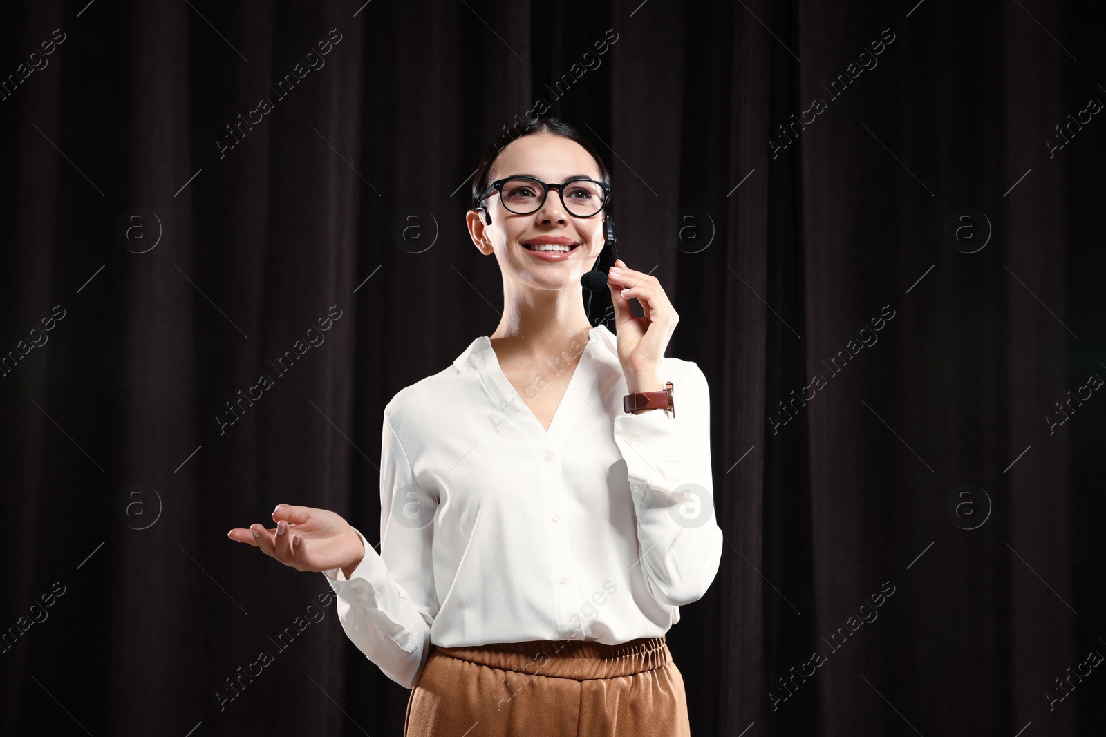 Photo of Motivational speaker with headset performing on stage