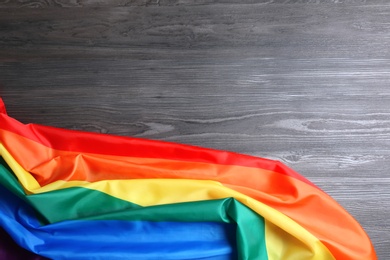 Bright rainbow gay flag on wooden background, top view with space for text. LGBT community