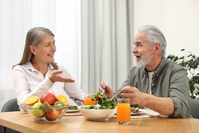 Happy senior couple having dinner at home