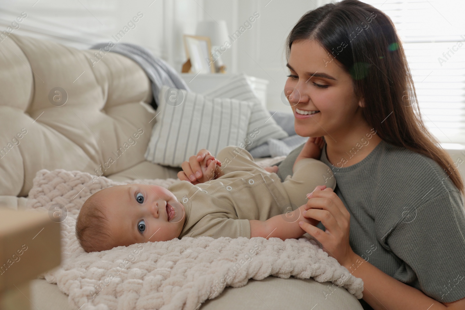 Photo of Young woman with her little baby at home