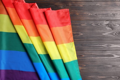 Bright rainbow gay flag on wooden background, top view with space for text. LGBT community