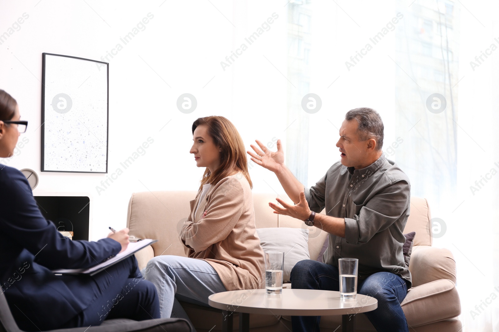 Photo of Psychotherapist working with couple in office. Family counselling