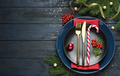 Beautiful Christmas table setting on dark wooden background, flat lay. Space for text