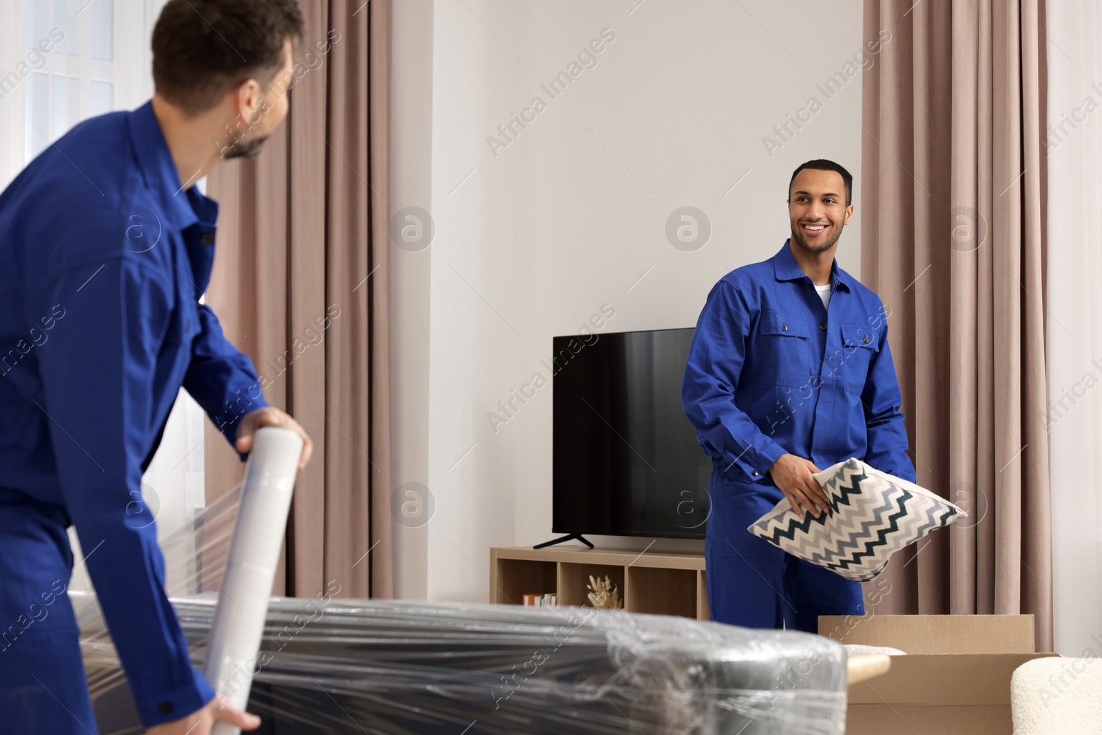 Photo of Male movers with sofa and pillow in new house