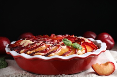 Photo of Delicious cake with plums in baking dish, closeup