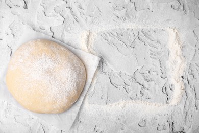 Frame made of flour and fresh dough on white textured table, top view. Space for text