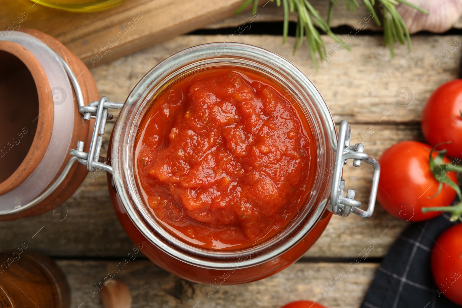 Photo of Homemade tomato sauce in jar on wooden table, top view