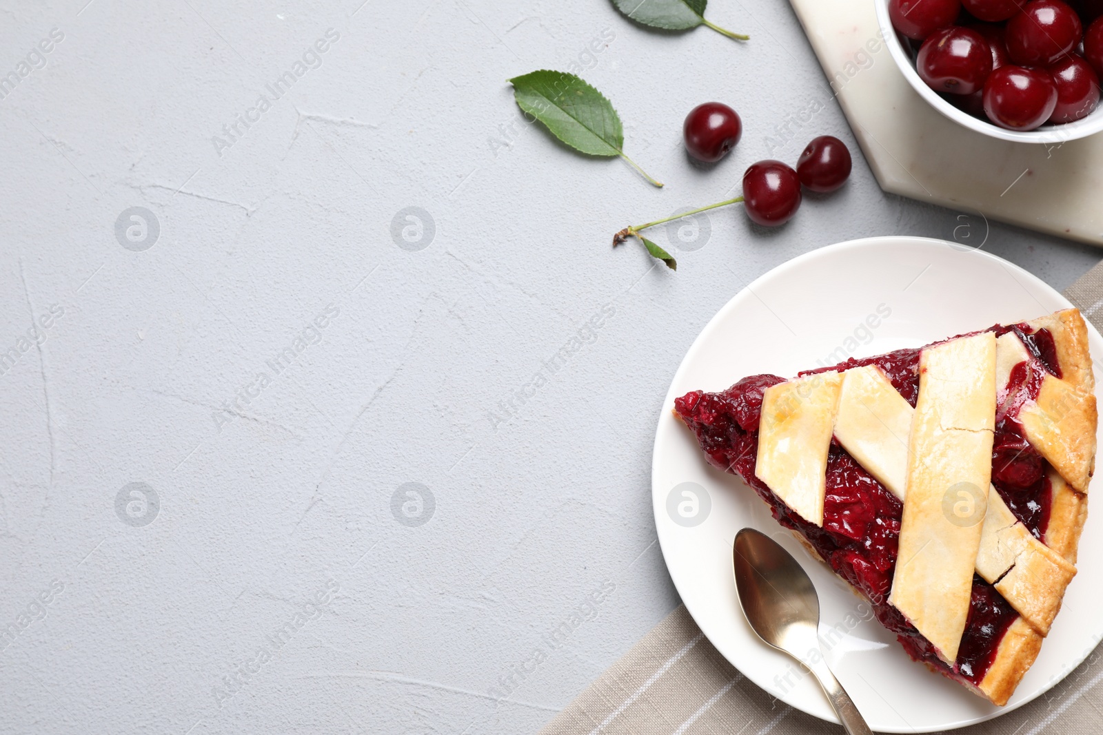 Photo of Delicious fresh cherry pie served on light grey table, flat lay. Space for text