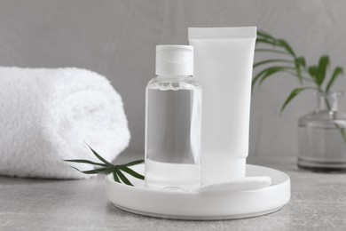 Photo of Micellar water and cream on grey table