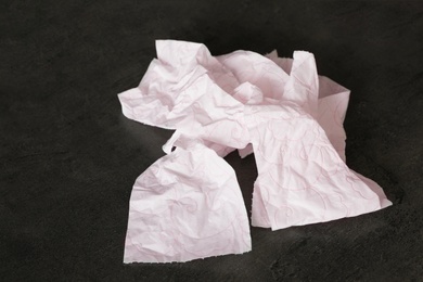 Photo of Crumpled soft toilet paper on black background
