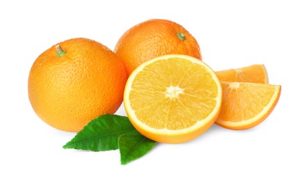 Photo of Cut and whole fresh ripe oranges with green leaves on white background