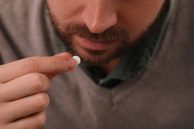 Photo of Closeup view of man taking antidepressant pill