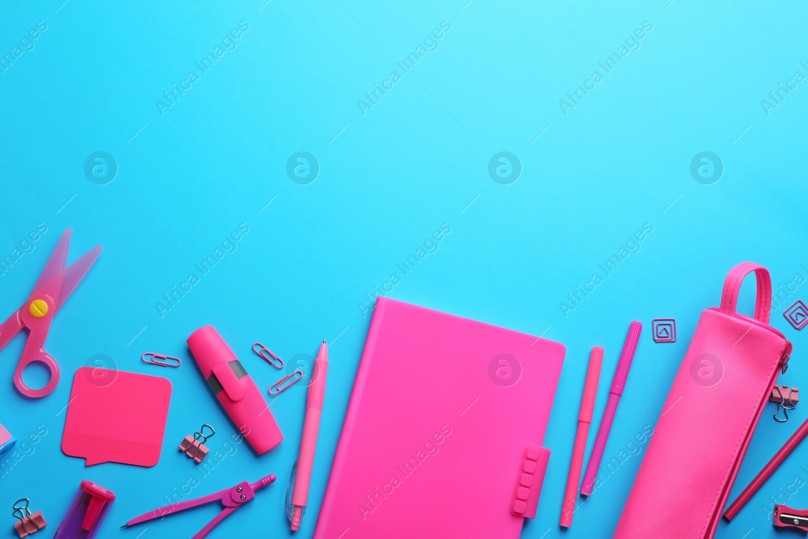 Photo of Colorful school stationery on light blue background, flat lay. Space for text