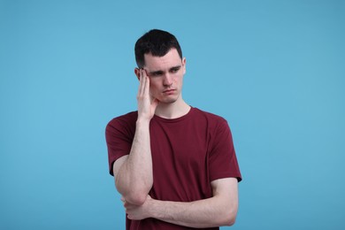 Photo of Portrait of sad man on light blue background