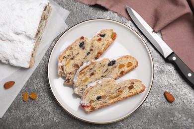 Photo of Traditional Christmas Stollen with icing sugar on grey table, flat lay
