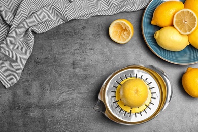 Photo of Flat lay composition with squeezer, fresh lemons and space for text on table