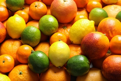 Different citrus fruits as background, closeup. Healthy diet