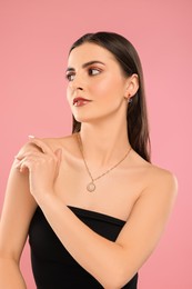 Beautiful woman with elegant jewelry on pink background