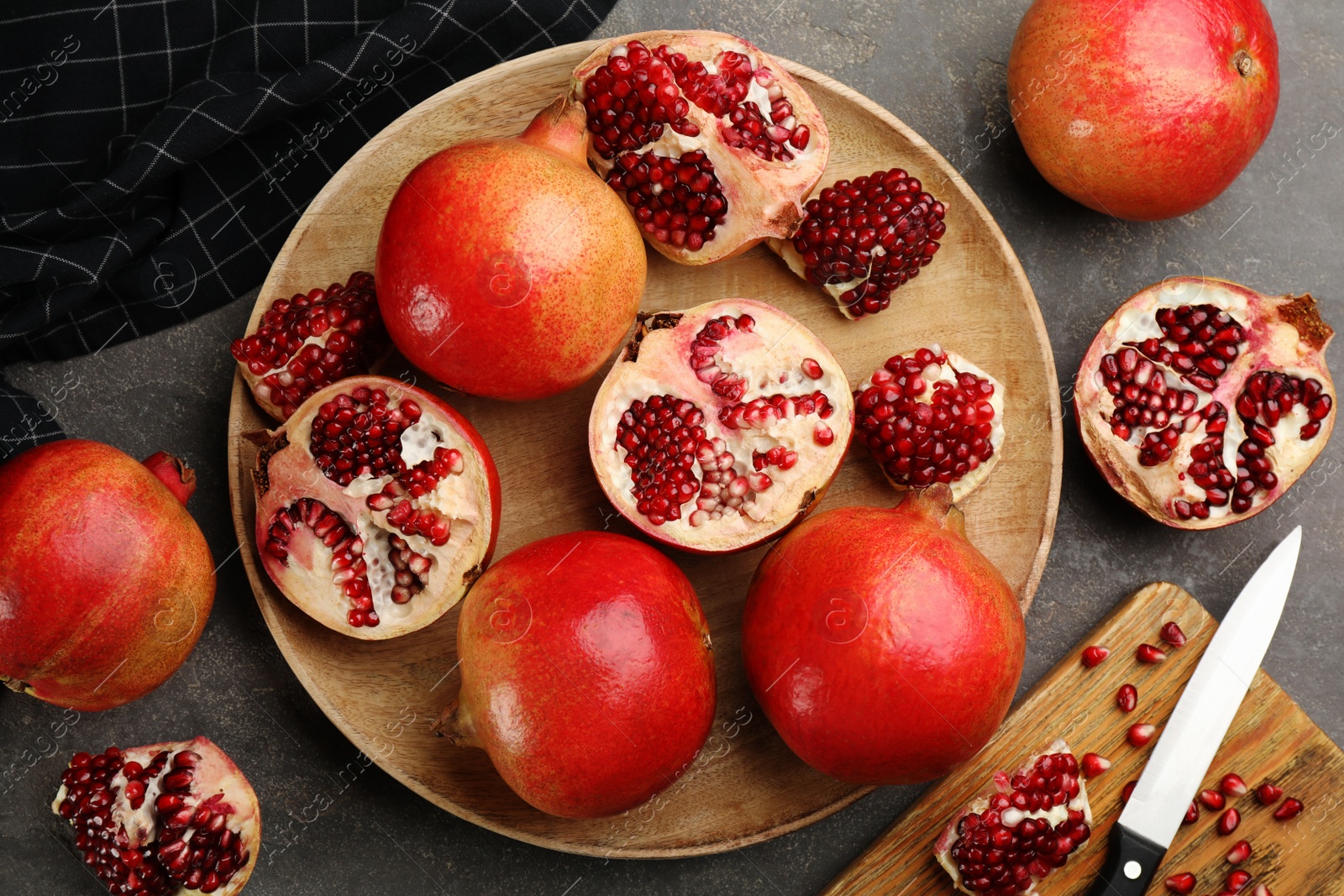 Photo of Delicious ripe pomegranates on grey table, flat lay