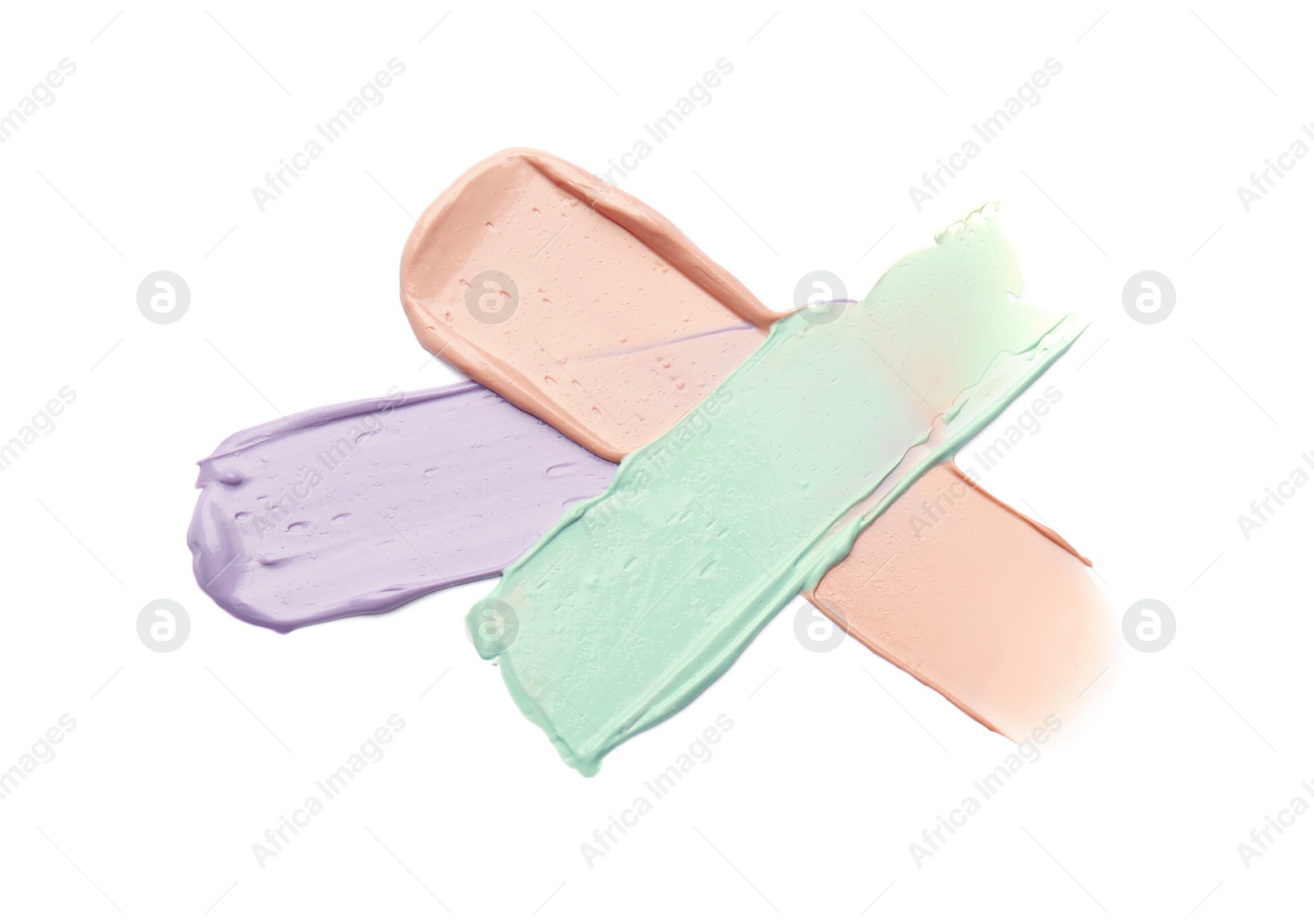 Photo of Strokes of pink, green and purple color correcting concealers isolated on white, top view